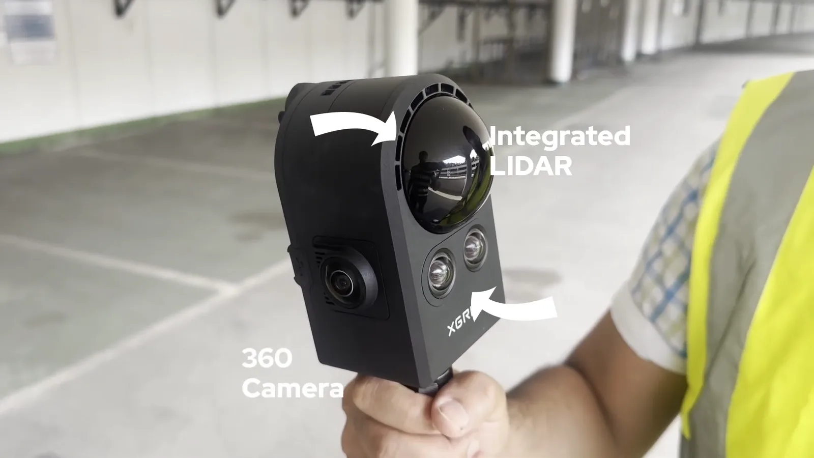 A technician holding the XGRIDS PortalCam handheld 3D LiDAR scanner inside a parking garage